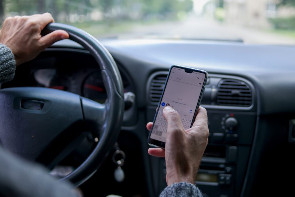 A man use smartphone while driving in the car. Road danger concept