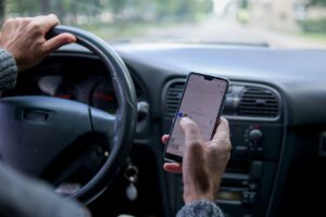 A man use smartphone while driving in the car. Road danger concept