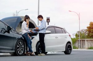 Woman driver calls for instruction during insurance agent review the dammage of the car after accident
